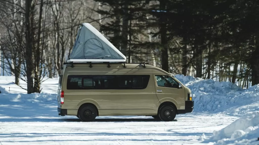 雪の林に停めたキャンピングカー