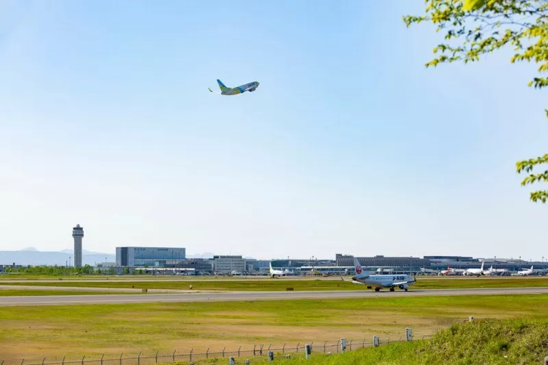 新千歳空港の滑走路と管制塔、離陸する飛行機